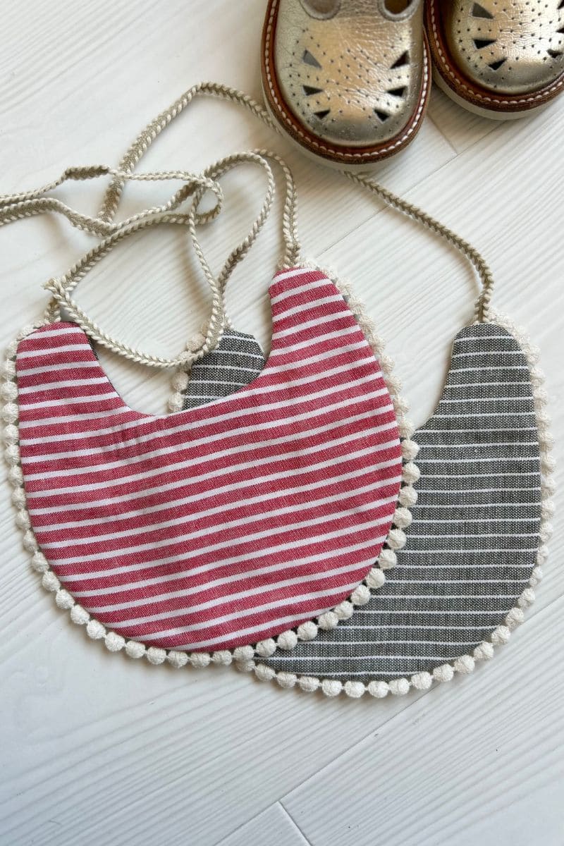 Bavoirs bébé avec bordure pompoms et petites chaussures dorées